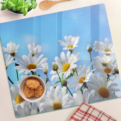 Glasschneidebrett Gänseblümchen auf blauem Hintergrund