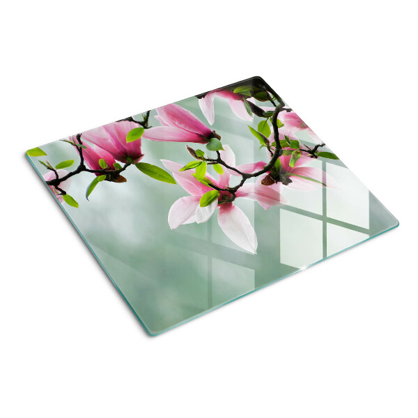 Glasschneidebrett Magnolienblüten vor einem grünen Hintergrund