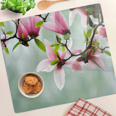 Glasschneidebrett Magnolienblüten vor einem grünen Hintergrund