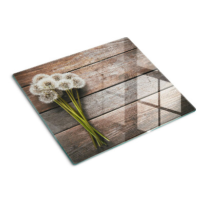 Glasschneidebrett Löwenzahnblüten auf einem hölzernen Hintergrund