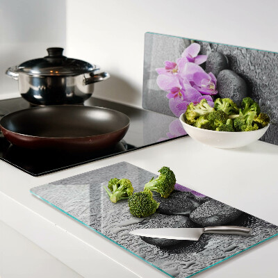 Schneidebrett glas Blumen und Steine gegen das Wasser