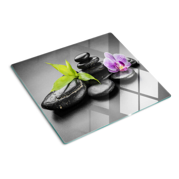 Glasschneidebrett Steine und Orchideen im Hintergrund