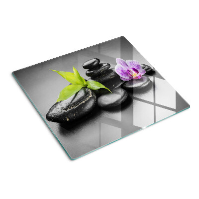 Glasschneidebrett Steine und Orchideen im Hintergrund
