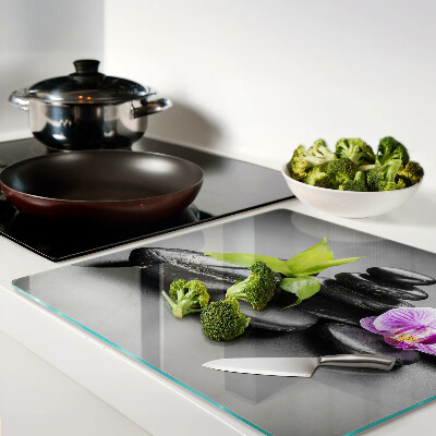 Glasschneidebrett Steine und Orchideen im Hintergrund