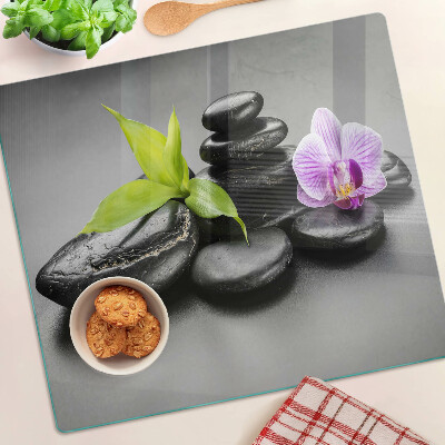 Glasschneidebrett Steine und Orchideen im Hintergrund