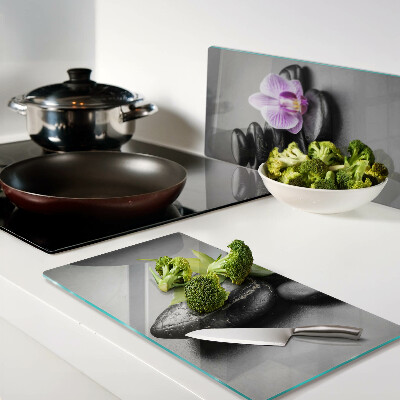 Glasschneidebrett Steine und Orchideen im Hintergrund