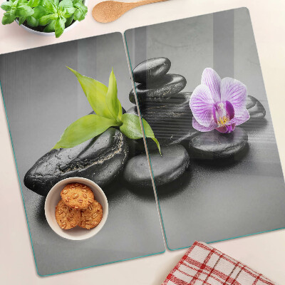 Glasschneidebrett Steine und Orchideen im Hintergrund