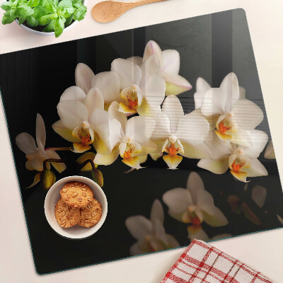 Schneidebrett glas Orchideen auf schwarzem Hintergrund