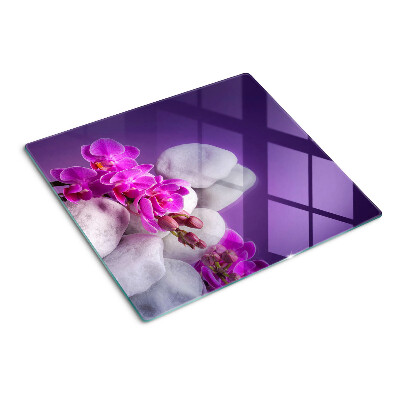 Schneidebrett glas Orchideenblüten auf einem Hintergrund aus Steinen