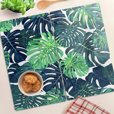 Glasschneidebrett Monstera-Blätter auf tropischem Hintergrund