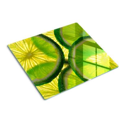 Glasschneidebrett Limettenscheiben auf grünem Hintergrund