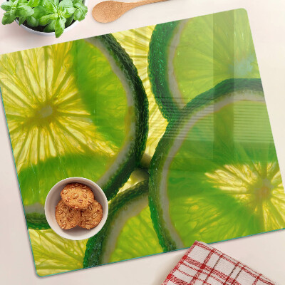 Glasschneidebrett Limettenscheiben auf grünem Hintergrund