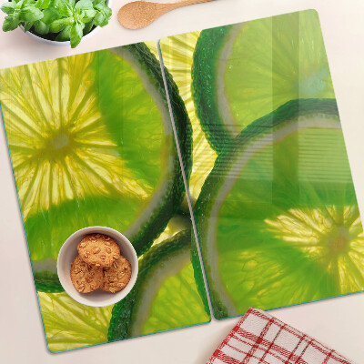 Glasschneidebrett Limettenscheiben auf grünem Hintergrund