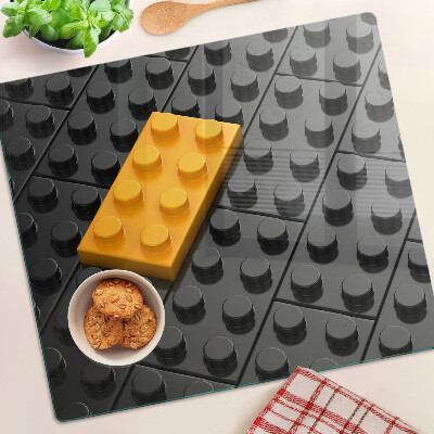 Schneidebrett glas LEGO Steine auf schwarzem Hintergrund