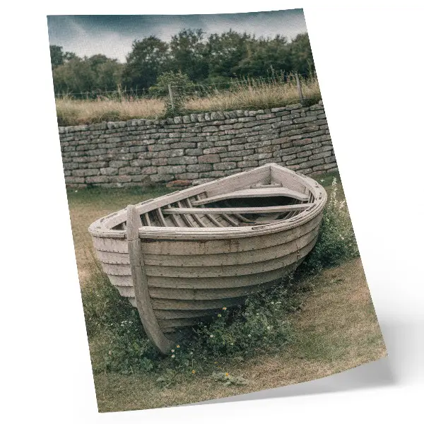 Kunstdruck auf Leinwand verlassenes Boot bei einer Mauer inmitten von Gras und Natur