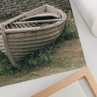 Kunstdruck auf Leinwand verlassenes Boot bei einer Mauer inmitten von Gras und Natur