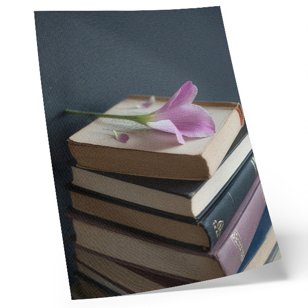 Kunstdruck leinwand Ein Bücherstapel mit einer zarten Blume darauf.