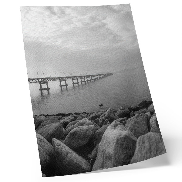 Poster Friedliche Landschaft, Brücke, felsiger Strand, grauer Himmel