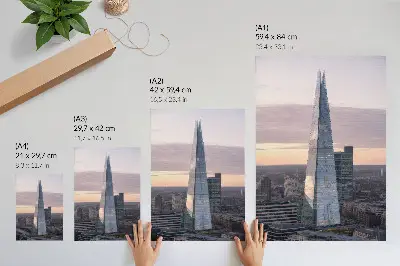 Wandposter mit einem Wolkenkratzer im Sonnenuntergang als Kontrast zur Stadt