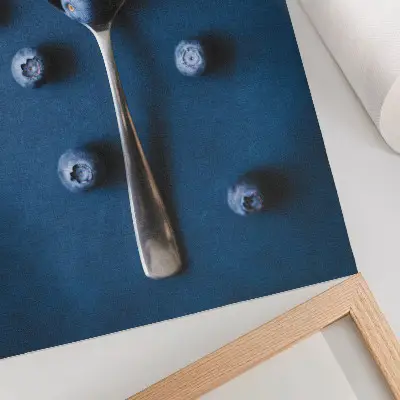 Leinwand Kunstdruck Blaubeeren auf einem Löffel vor blauem Hintergrund im eleganten Stil