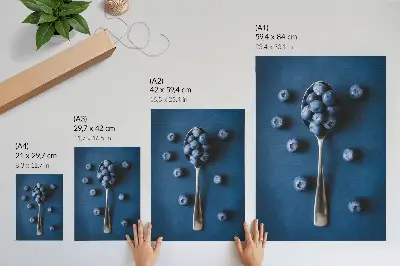 Leinwand Kunstdruck Blaubeeren auf einem Löffel vor blauem Hintergrund im eleganten Stil