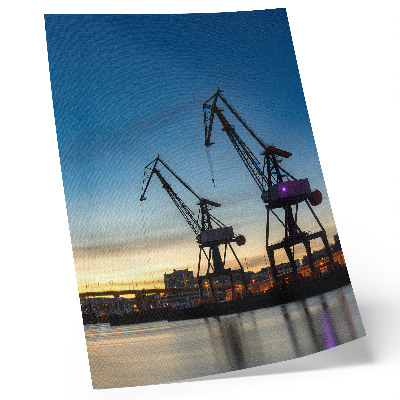 Wandposter Kräne vor der Kulisse eines dynamischen Sonnenuntergangs
