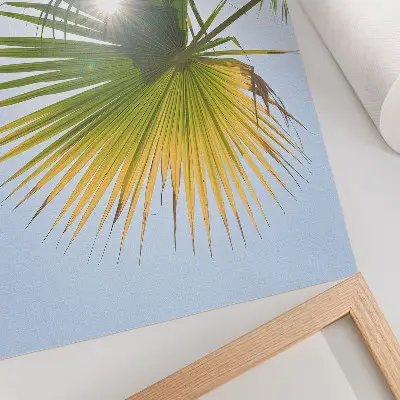 Wandposter Palmenblätter vor blauem Hintergrund mit Sonnenlicht