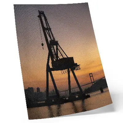 Poster Silhouette eines Industriekrans bei Sonnenuntergang an einer Brücke
