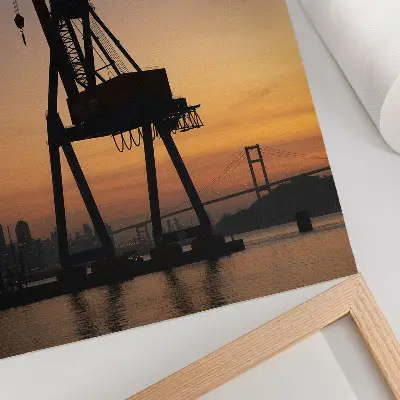 Poster Silhouette eines Industriekrans bei Sonnenuntergang an einer Brücke