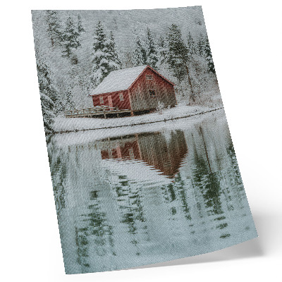 Poster Ein rotes Häuschen zwischen schneebedeckten Bäumen am Wasser