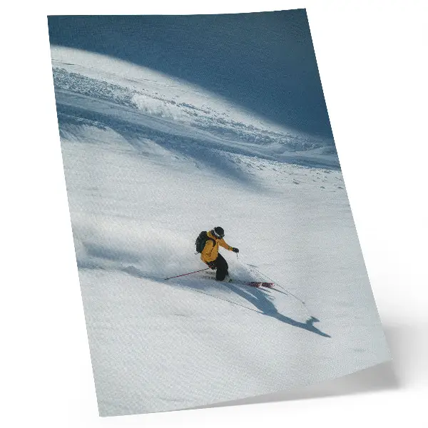 Leinwand Kunstdruck Skifahrer in gelber Jacke am Schneehang mit Schatten