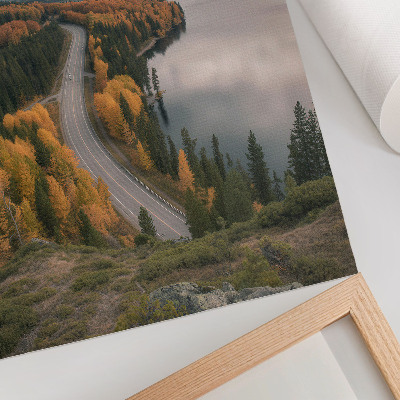 Wandposter Eine malerische Straße zwischen den Bäumen am Seeufer