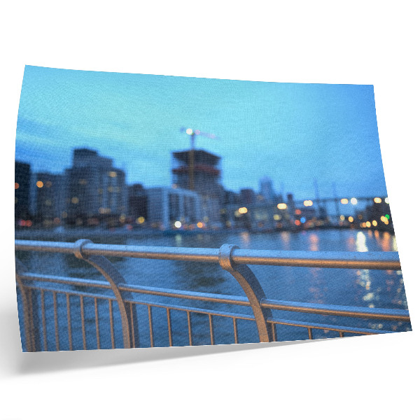 Poster Die Uferpromenade der Stadt am Abend mit verschwommenen Lichtern