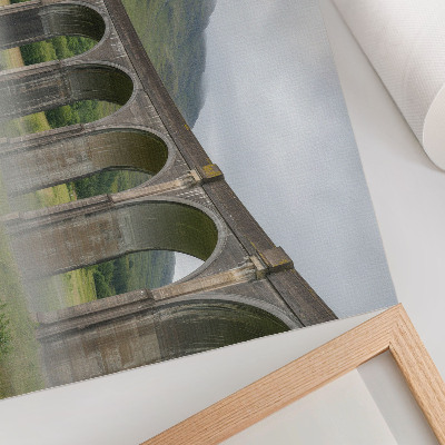 Poster Eine majestätische Bogenbrücke inmitten von Grün