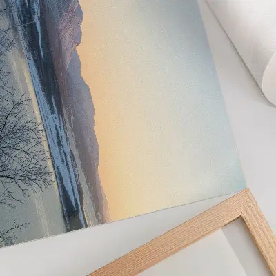 Poster mit einer Winterlandschaft mit Bergen, Wasser und Bäumen in der Abenddämmerung