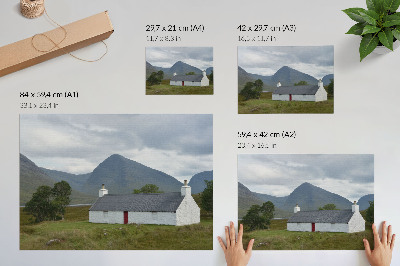 Kunstdruck poster Ein weißes Häuschen inmitten von Bergen und Grün