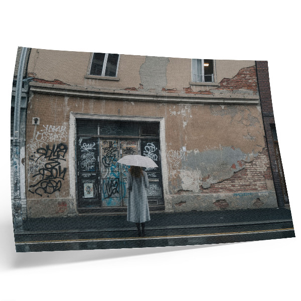 Poster Eine Person mit einem Regenschirm vor einer mit Graffiti bedeckten Wand