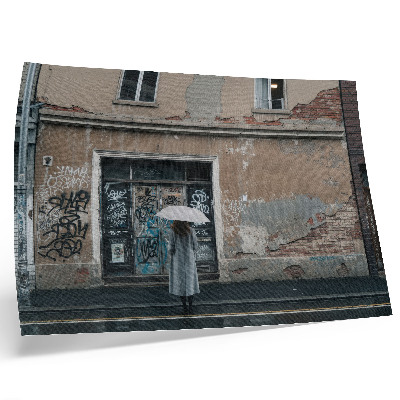 Poster Eine Person mit einem Regenschirm vor einer mit Graffiti bedeckten Wand