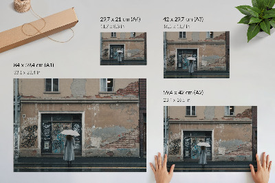 Poster Eine Person mit einem Regenschirm vor einer mit Graffiti bedeckten Wand