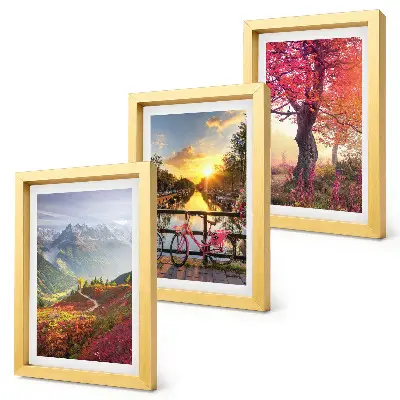 Bilderwand mit Berglandschaften, einem Fahrrad und einem Herbstbaum