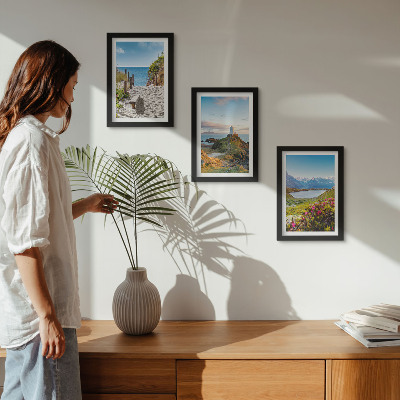 Bilderwand Blick auf den Leuchtturm, den Strand, die Berge und die Blumen