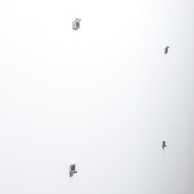 Das Bild ist mit vier Kleiderbügeln montiert. An der Wand montierte Spiegelbügel