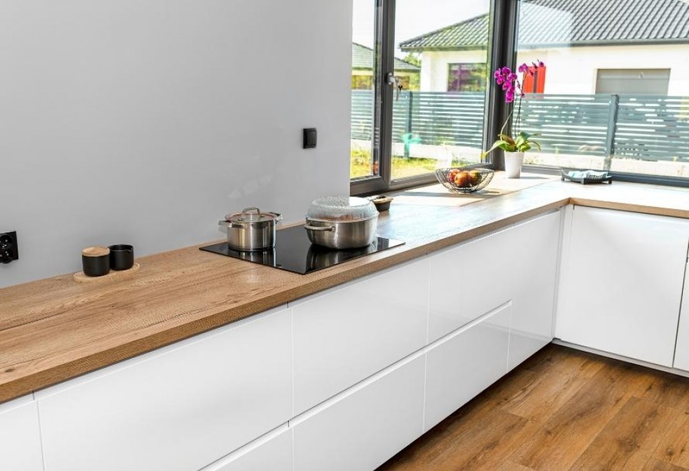 weiße Küche mit einer Arbeitsplatte aus Holz