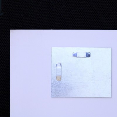 Das Bild wird mit zwei Kleiderbügeln montiert. Die Kleiderbügel werden an zwei Stellen auf das Gemälde geklebt